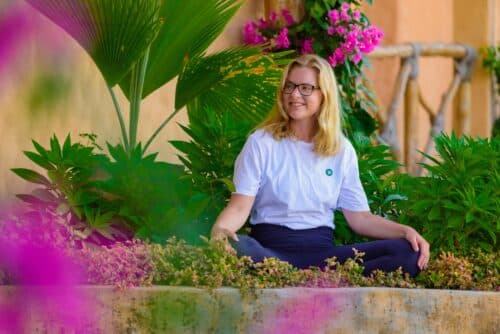 Cathrine sidder i skrædderstilling i haven på Bali