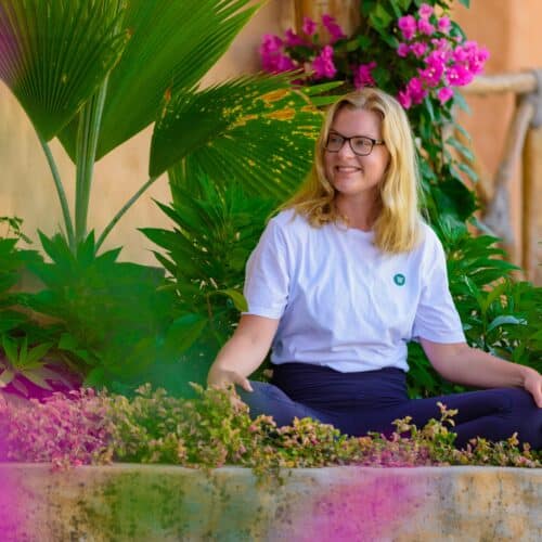 Cathrine sidder i skrædderstilling i haven på Bali