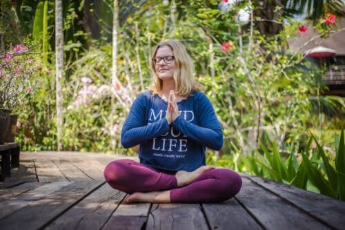 Cathrine mediterer på træterasse på yogarejse