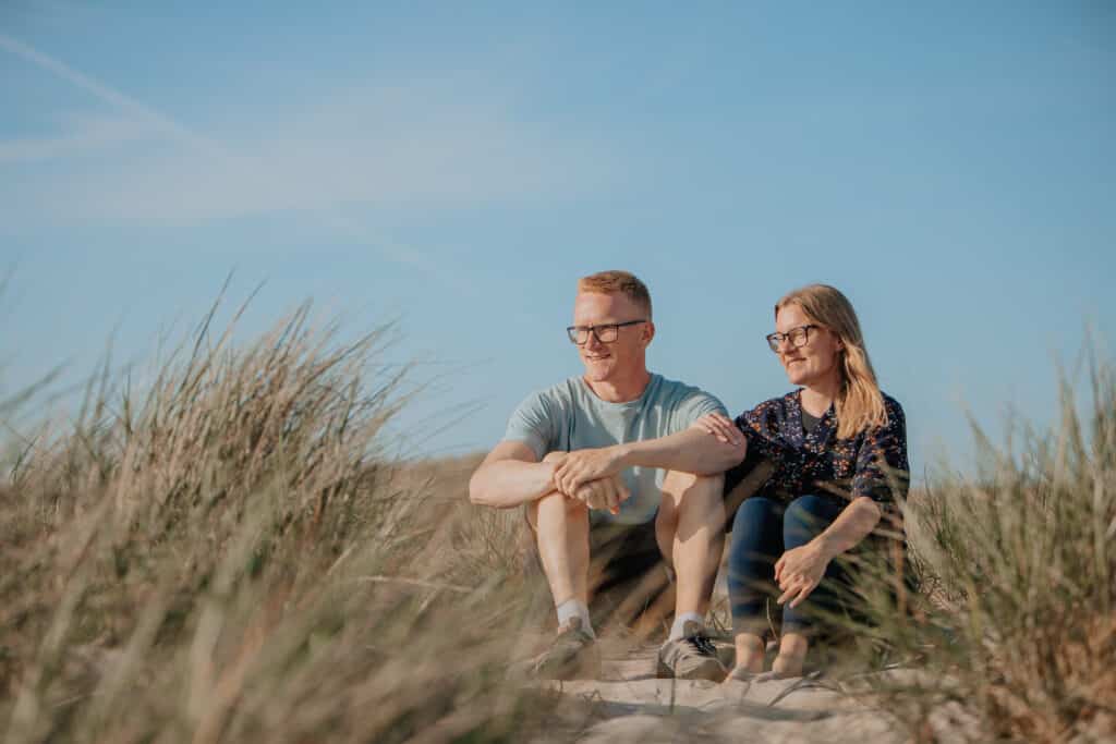 Cathrine og Tommy sidder i klittene på yogaferie i Vestjylland