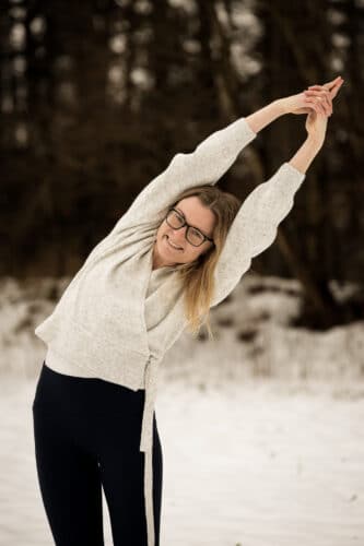 Cathrine laver yogaøvelse i vinterlandskab på yogaferie i Sverige