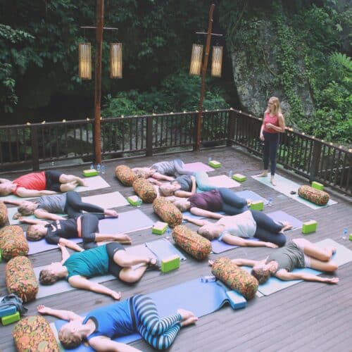 Cathrine underviser kommende yogalærere yogaøvelsen twist på terasse på Bali