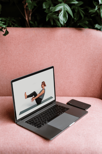 Laptop med Cathrine Yoga Online i lyserød sofa