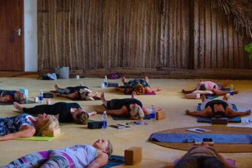 Yogaelever der hviler i savasana på yoga retreat på Zanzibar