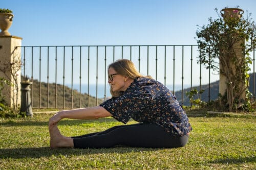 Cathrine laver et yogastræk i haven i Spanien med udsigt til bjerge og hav