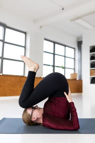Cathrine viser en yogastilling fra yogaklasen Yoga for hovedet