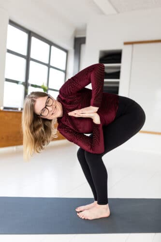 Cathrine viser et stående yogatwist fra Yang Yogakuren