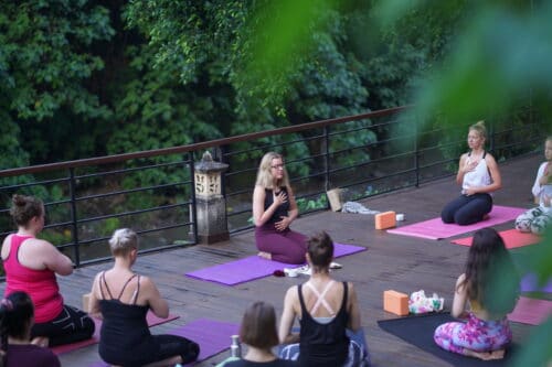 Cathrine underviser yogaelever i Mindfulness på træterasse på Bali